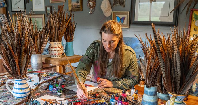 Clare Brownlow painting with pheasant feathers